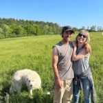 Leaping Bear Farm eggs available at Woodstock Farmers' Market. Image shows a man, woman, and Great Pyrenees dog standing in a green pasture.
